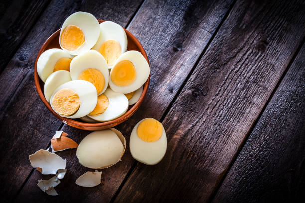 Top view of a brown clay bowl filled with hard-boiled eggs.